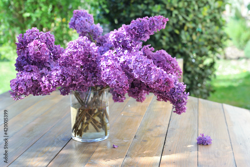 beautiful bouquet of purple lilac on awooden table in garden