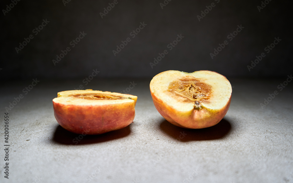 Slice of apple on black background. The middle of the apple is rot. Slice of apple on black background. The middle of the apple is rot.
