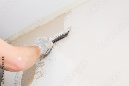 Process putty concrete wall with a metal spatula.process of applying a layer of putty. Renovation of apartments. Repair the walls. Free space for advertising, text.Repair of the living quarters.