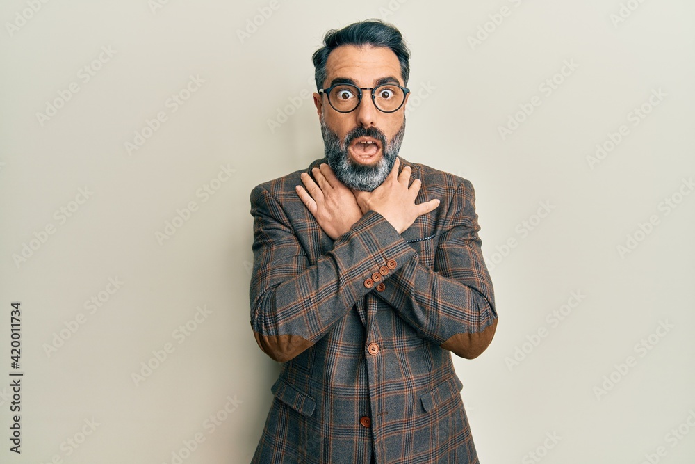 Middle age man with beard and grey hair wearing business jacket and glasses shouting and suffocate because painful strangle. health problem. asphyxiate and suicide concept. Middle age man with beard and grey hair wearing business jacket and glasses shouting and suffocate because painful strangle. health problem. asphyxiate and suicide concept.