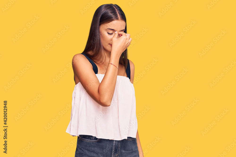 Young hispanic woman wearing casual clothes tired rubbing nose and eyes feeling fatigue and headache. stress and frustration concept. Young hispanic woman wearing casual clothes tired rubbing nose and eyes feeling fatigue and headache. stress and frustration concept.