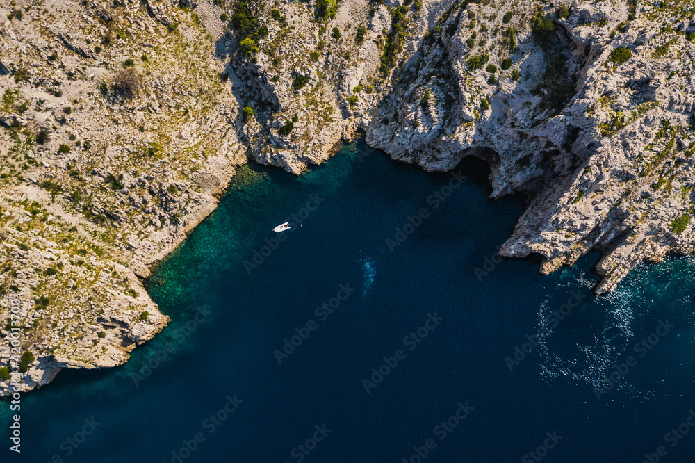 Top view of rocky coastline with turquoise water.