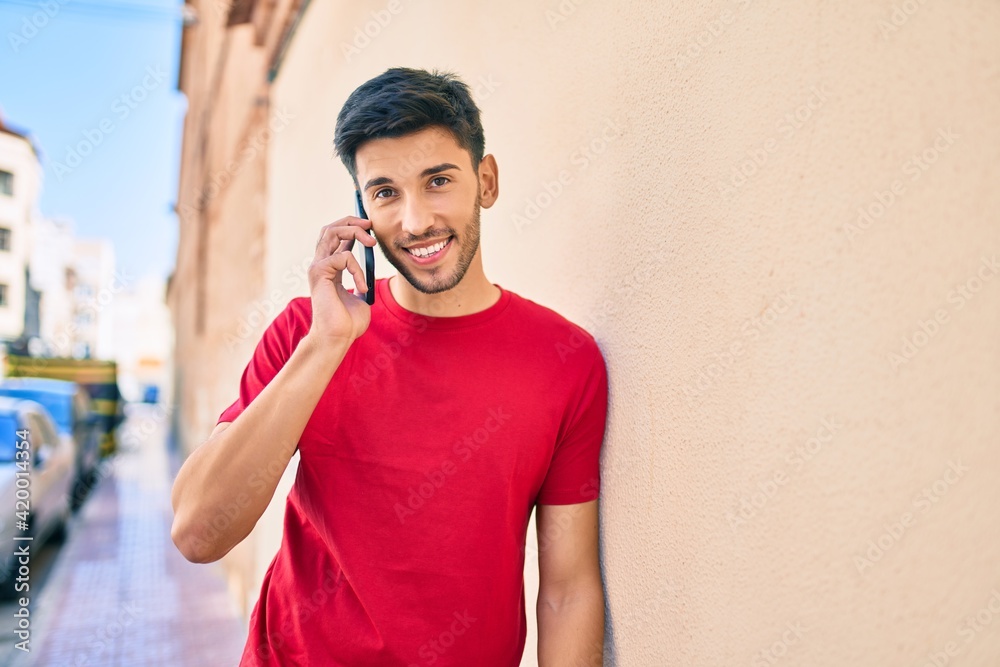 Young latin man smiling happy talking on the smartphone at the city. Young latin man smiling happy talking on the smartphone at the city.
