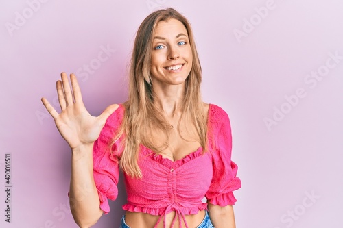 Beautiful caucasian woman wearing casual clothes showing and pointing up with fingers number five while smiling confident and happy. © Krakenimages.com