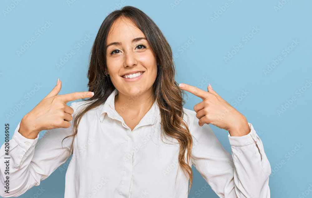 Young brunette woman wearing casual clothes smiling cheerful showing and pointing with fingers teeth and mouth. dental health concept. Young brunette woman wearing casual clothes smiling cheerful showing and pointing with fingers teeth and mouth. dental health concept.