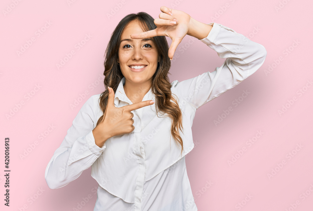 Young brunette woman wearing casual clothes smiling making frame with hands and fingers with happy face. creativity and photography concept. Young brunette woman wearing casual clothes smiling making frame with hands and fingers with happy face. creativity and photography concept.