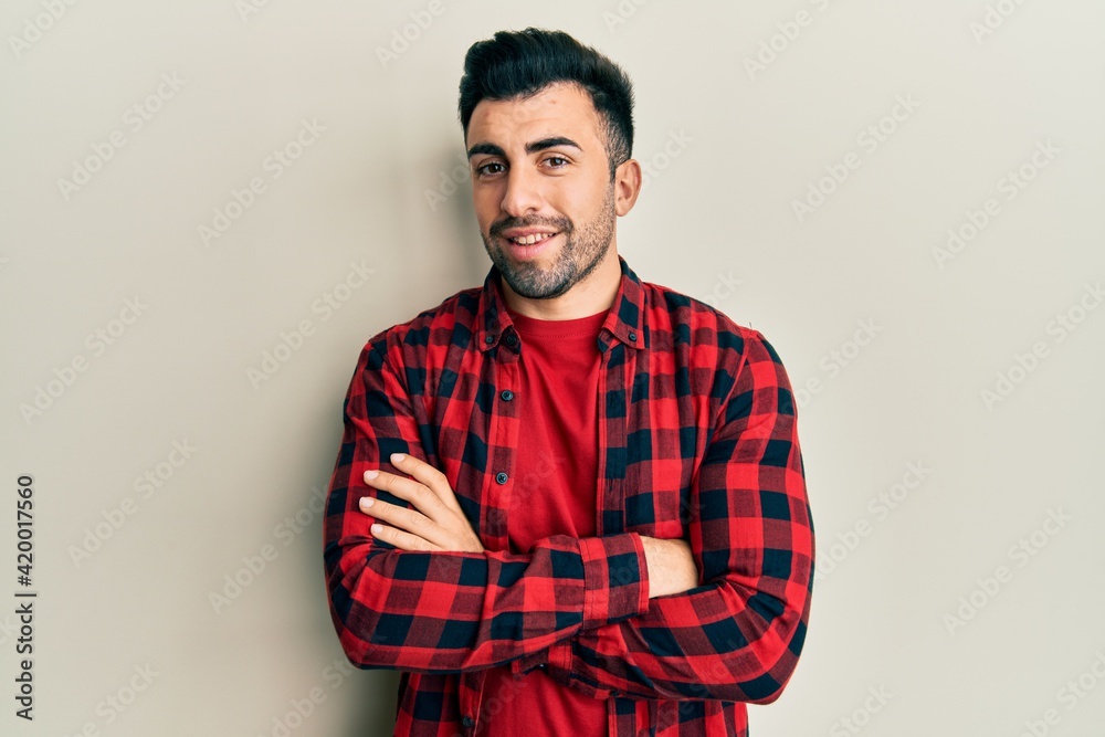 Fototapeta premium Young hispanic man wearing casual clothes happy face smiling with crossed arms looking at the camera. positive person.