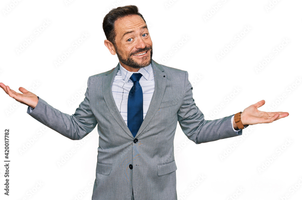 Middle age man wearing business clothes smiling showing both hands open palms, presenting and advertising comparison and balance Middle age man wearing business clothes smiling showing both hands open palms, presenting and advertising comparison and balance