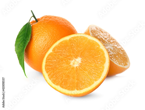 Cut and whole fresh ripe oranges with green leaf on white background