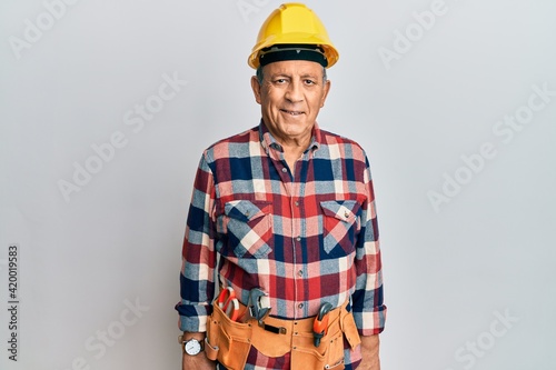 Senior hispanic man wearing handyman uniform with a happy and cool smile on face. lucky person.