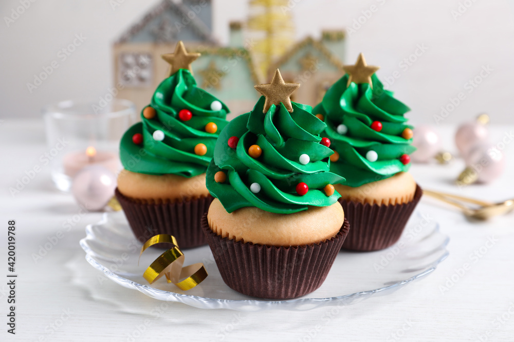 Christmas tree shaped cupcakes on white table Christmas tree shaped cupcakes on white table