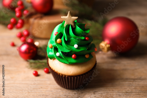 Christmas tree shaped cupcake on wooden table, closeup