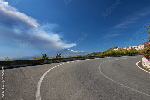 volcano in Sicily taken from the road that climbs to get to Taormina on a beautiful sunny day in spring 2021, you can see the station and Giardini Naxos with the whole