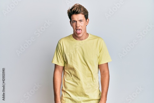 Wallpaper Mural Handsome caucasian man wearing casual clothes sticking tongue out happy with funny expression. emotion concept. Torontodigital.ca