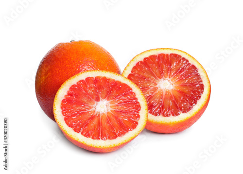 Whole and cut red oranges on white background