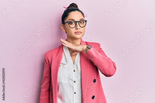 Beautiful middle eastern woman wearing business jacket and glasses cutting throat with hand as knife, threaten aggression with furious violence
