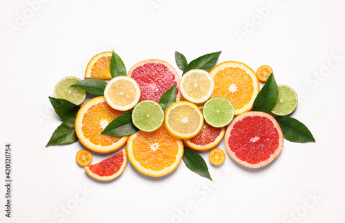 Fototapeta Naklejka Na Ścianę i Meble -  Fresh juicy citrus fruits with green leaves on white background, flat lay