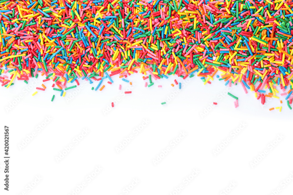 Fototapeta premium Colorful sprinkles on white background, top view. Confectionery decor