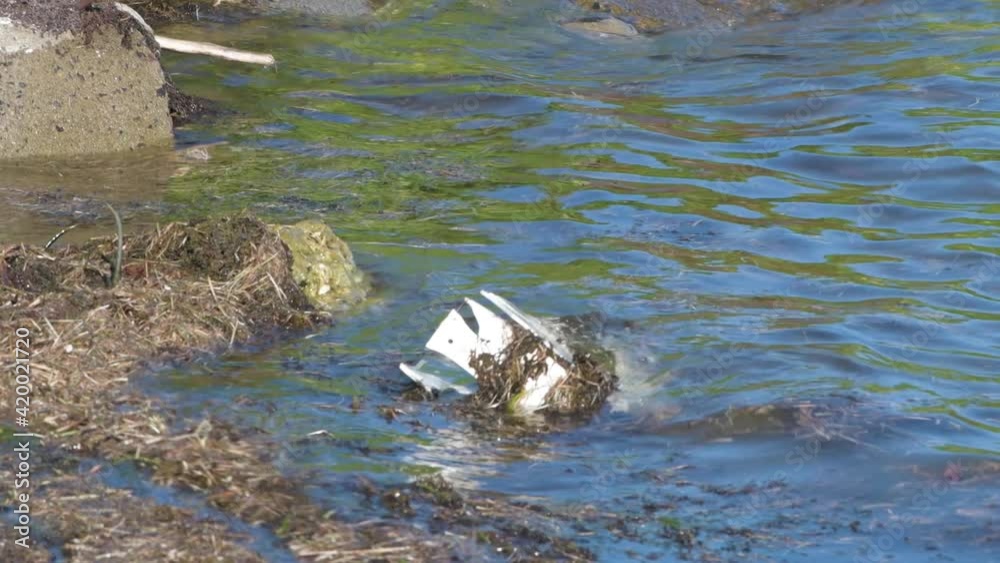 Discarded, old plastic item floating in the ocean Discarded, old plastic item floating in the ocean