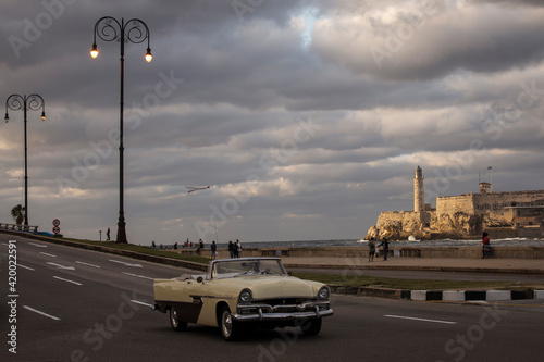 Old car on Malecon street of Havana with storm clouds in background. Cuba