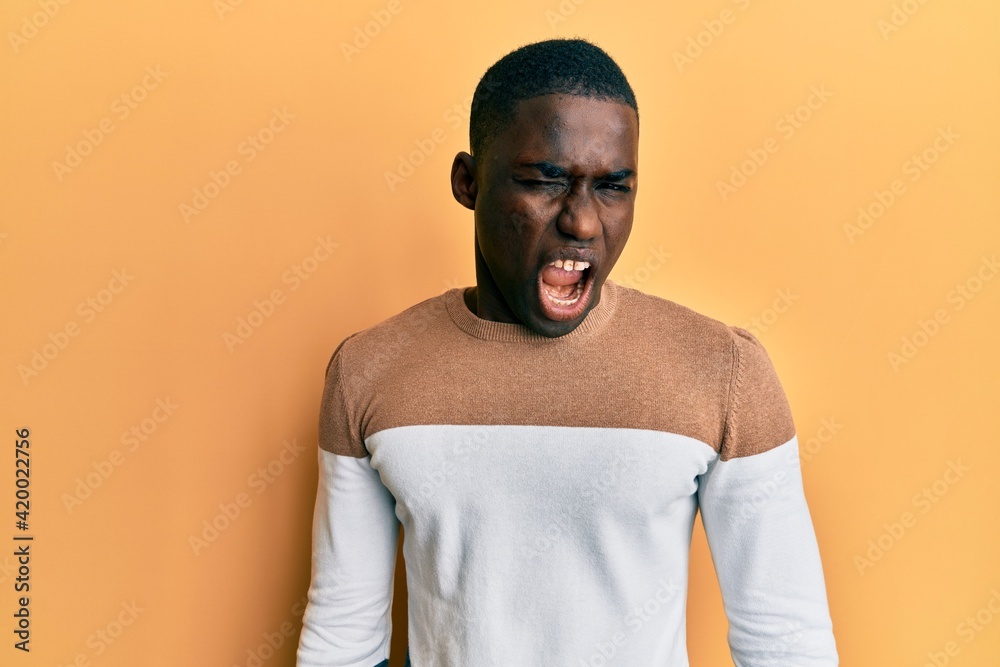 Young african american man wearing casual clothes winking looking at the camera with sexy expression, cheerful and happy face. Young african american man wearing casual clothes winking looking at the camera with sexy expression, cheerful and happy face.