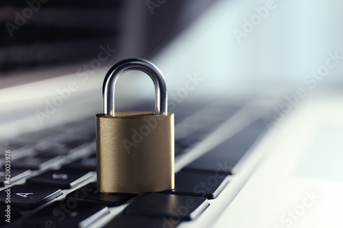 Metal padlock on laptop keyboard, space for text. Cyber security concept