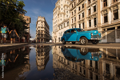 Old car on streets of Havana with colourful buildings in background. Cuba