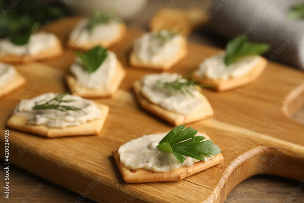 Delicious crackers with humus, parsley and dill on wooden table, closeup Delicious crackers with humus, parsley and dill on wooden table, closeup