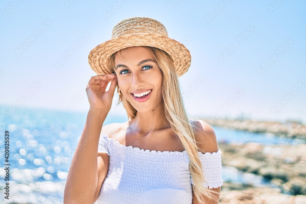 Young blonde tourist girl smiling happy looking to the camera walking at the promenade.