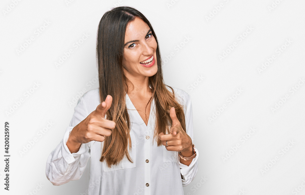 Young beautiful woman wearing casual clothes pointing fingers to camera with happy and funny face. good energy and vibes. Young beautiful woman wearing casual clothes pointing fingers to camera with happy and funny face. good energy and vibes.