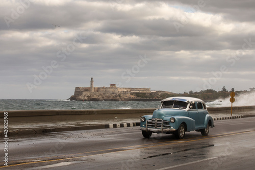 Old car on Malecon street of Havana with storm clouds in background. Cuba © danmir12