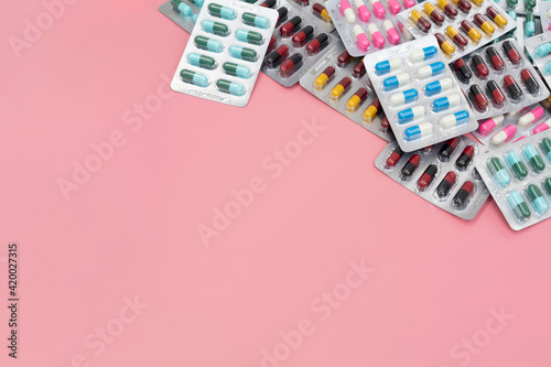 Antibiotic drug capsule pills in blister package isolated on pink background with copy space. Medicine background of pharmaceuticals antibiotics pills medicine. photo