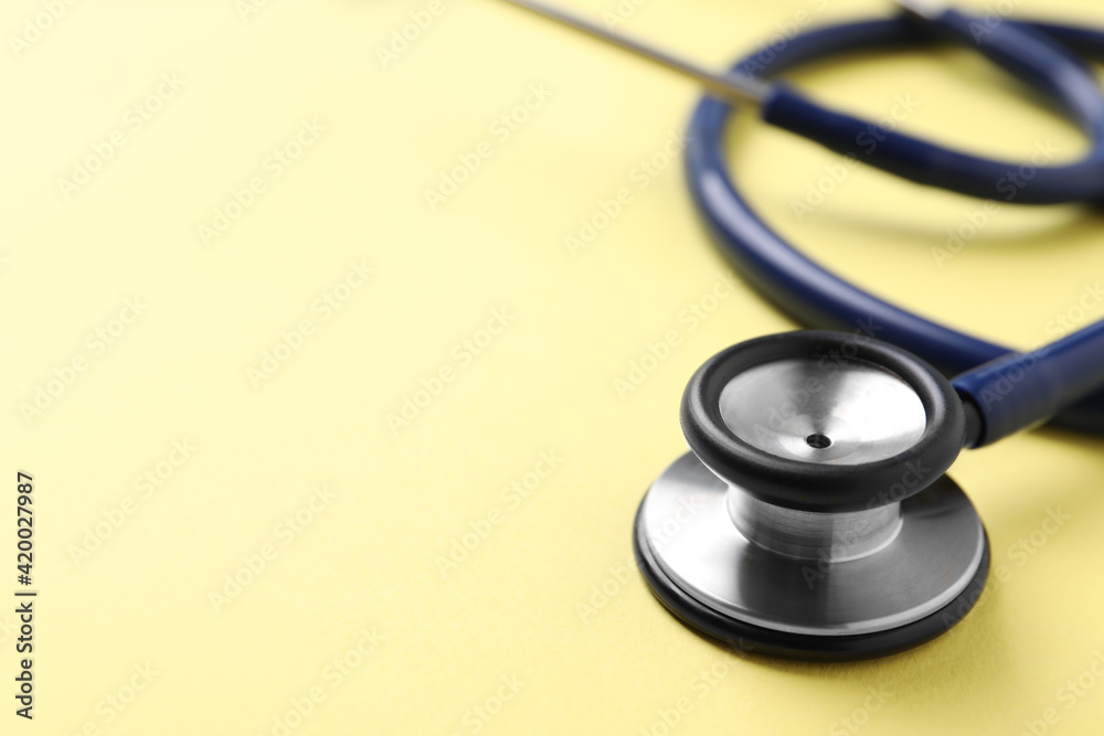 Stethoscope on yellow background, closeup. Space for text Stethoscope on yellow background, closeup. Space for text