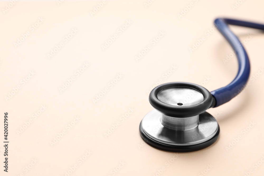 Stethoscope on beige background, closeup. Space for text Stethoscope on beige background, closeup. Space for text