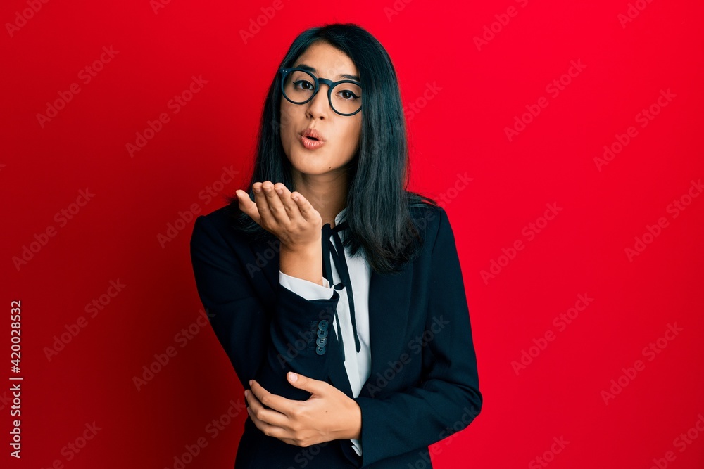 Beautiful asian young woman wearing business suit looking at the camera blowing a kiss with hand on air being lovely and sexy. love expression. Beautiful asian young woman wearing business suit looking at the camera blowing a kiss with hand on air being lovely and sexy. love expression.