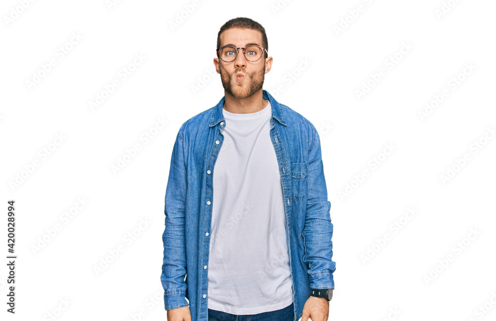 Fototapeta premium Young caucasian man wearing casual clothes making fish face with lips, crazy and comical gesture. funny expression.