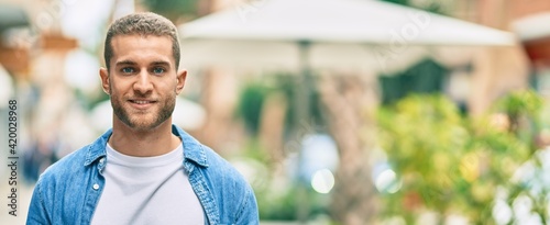 Young caucasian man smiling happy standing at the city.