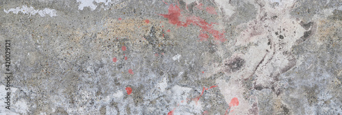 Concrete wall. Weathered old paints on the spilled wall.