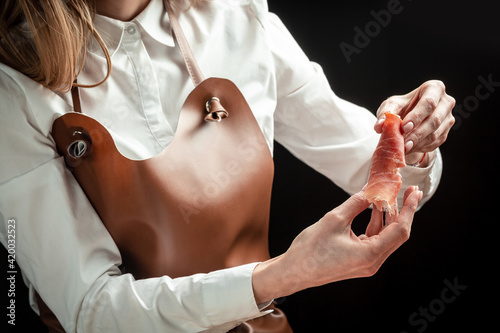 Fotografie, Obraz Woman holding Italian prosciutto crudo or spanish jamon