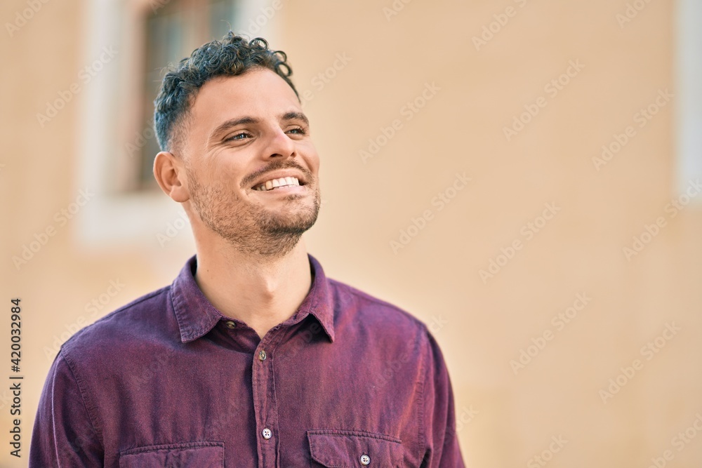 Obraz premium Young hispanic man smiling happy standing at the city.