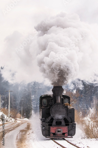 Old train with big smoke during winter time in Moldovita, Bucovina. Romaniia.