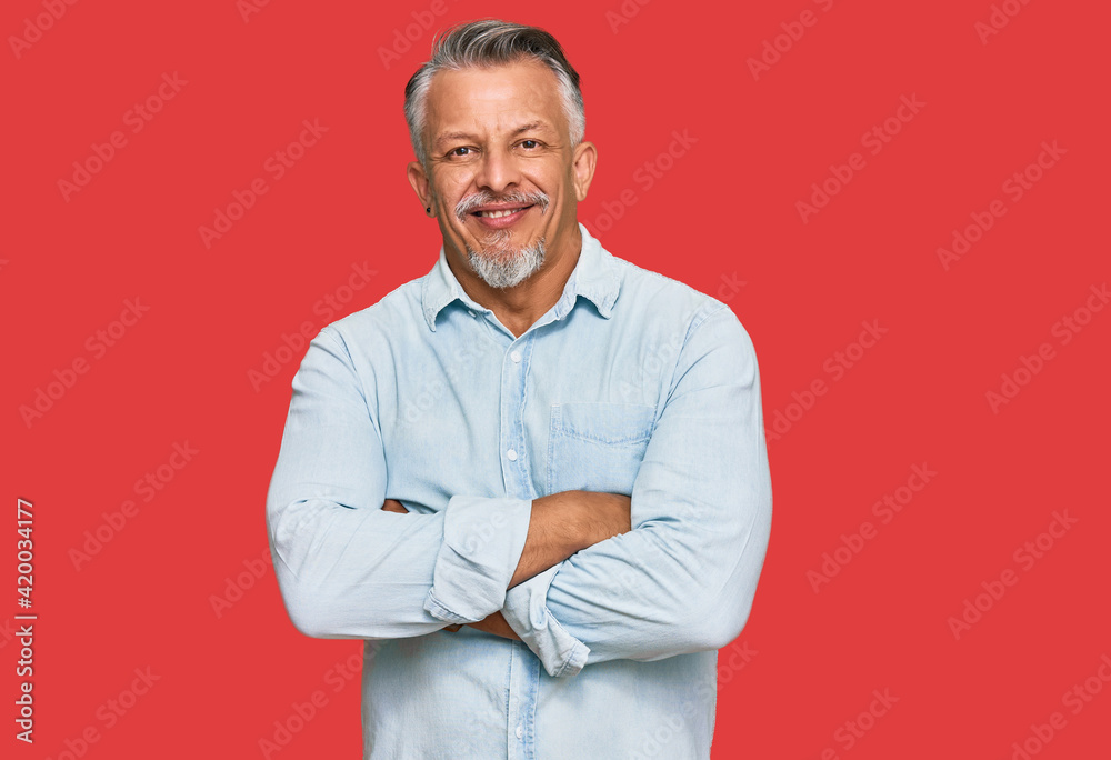 Middle age grey-haired man wearing casual clothes happy face smiling with crossed arms looking at the camera. positive person.