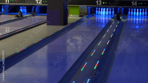 The ball hits the pins. Colorful bowling lanes. Bowling game