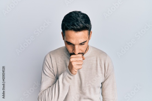 Young hispanic man wearing casual clothes feeling unwell and coughing as symptom for cold or bronchitis. health care concept.