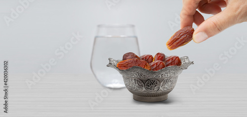 Typical of the month of Ramadan for muslims is the setting here, after the fast has been broken - water and pitted dates. Traditional iftar food.
metal bowl full of date fruits symbolizing Ramadan photo