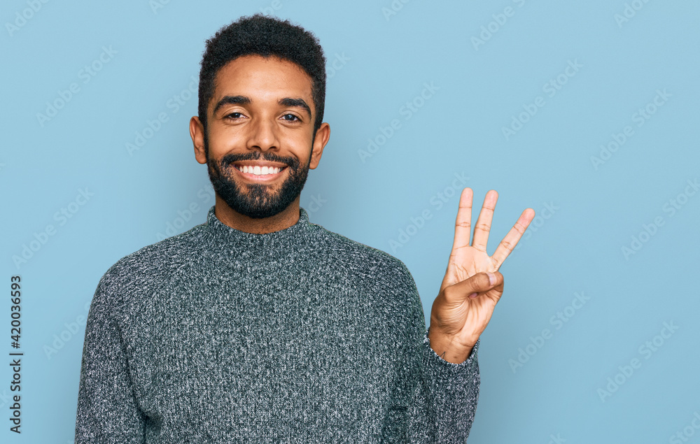 Young african american man wearing casual clothes showing and pointing up with fingers number three while smiling confident and happy.