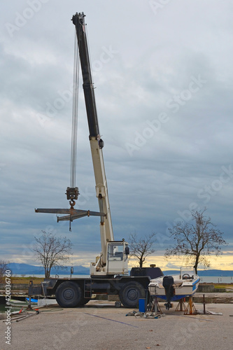 A hydraulic mobile suspended boat lift or hoist with a sling. Located in an out-of-season marina in northern Italy 