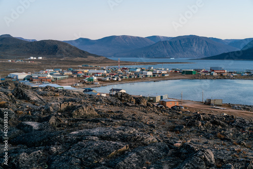 Dusk in a harsh arctic landscape with bare hills and ocean. Overlook of Inuit settlement of Qikiqtarjuaq, Broughton Island, Nunavut photo