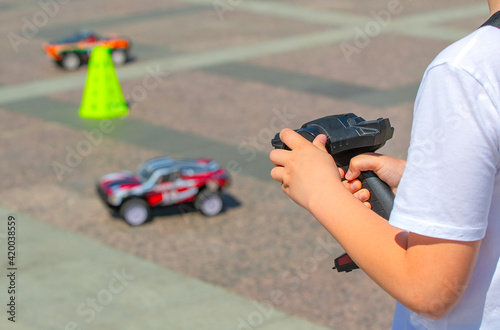 boy controls a toy car with a remote control