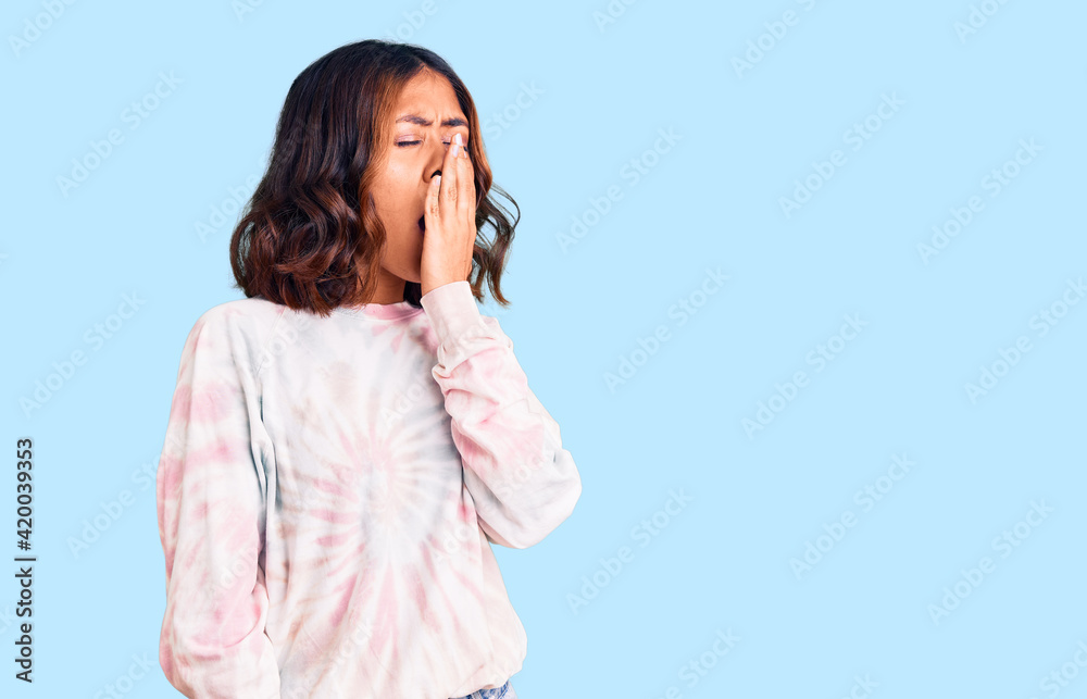 Young beautiful mixed race woman wearing casual tie dye sweatshirt bored yawning tired covering mouth with hand. restless and sleepiness. Young beautiful mixed race woman wearing casual tie dye sweatshirt bored yawning tired covering mouth with hand. restless and sleepiness.